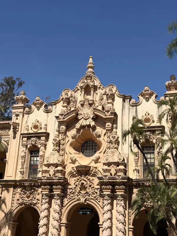 The carved stone front of a building in Balboa Park under a blue sky.